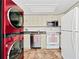 Bright kitchen featuring white cabinets, stainless steel appliances and red washer and dryer at 6052 Village Cir # 6052, Orlando, FL 32822