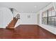 Spacious living room with wood floors, staircase, and lots of natural light at 6052 Village Cir # 6052, Orlando, FL 32822