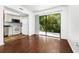 Cozy living room with wood floors, lots of natural light, and an adjacent kitchen at 6052 Village Cir # 6052, Orlando, FL 32822