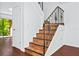 Interior shot of staircase showcasing the beautiful wood steps and decorative metal railing at 6052 Village Cir # 6052, Orlando, FL 32822