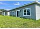 Exterior view of the home's backyard featuring a sliding door and lush green lawn at 611 Amazon Pl, Kissimmee, FL 34759