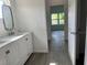 Modern bathroom featuring a double sink vanity with white cabinets and gray wood look flooring at 611 Amazon Pl, Kissimmee, FL 34759