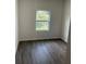 Minimalist bedroom with gray wood look flooring and a window offering natural light at 611 Amazon Pl, Kissimmee, FL 34759