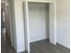 Bedroom with a gray floor and a closet with folding doors and wire shelving system at 611 Amazon Pl, Kissimmee, FL 34759