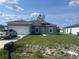 Charming single-story home with gray exterior, well-maintained lawn, and attached garage at 611 Amazon Pl, Kissimmee, FL 34759