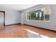Sunny living room featuring hardwood floors, a large window, and a white front door at 641 Jackson St, Eustis, FL 32726