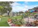 Spacious backyard featuring well-manicured lawn, colorful flowers, and a storage shed in the distance at 840 Del Prado Dr, Kissimmee, FL 34758