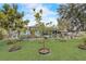 Expansive backyard with lush green grass, young trees, and an inviting outdoor seating area at 840 Del Prado Dr, Kissimmee, FL 34758