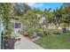 Lush backyard featuring a well-maintained lawn, a variety of plants, and a concrete walkway at 840 Del Prado Dr, Kissimmee, FL 34758