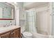 Bathroom featuring a vanity with brown cabinets, toilet, tub with shower, and a patterned shower curtain at 840 Del Prado Dr, Kissimmee, FL 34758