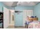 Bedroom showcases light blue walls, gray wood flooring, and a glimpse into the hallway at 840 Del Prado Dr, Kissimmee, FL 34758