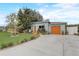 Charming single-story home with light blue exterior, orange doors, and beautiful landscaping at 840 Del Prado Dr, Kissimmee, FL 34758