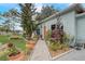Quaint home with a stone walkway and vibrant landscaping, creating a welcoming entrance at 840 Del Prado Dr, Kissimmee, FL 34758