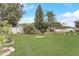 Well-manicured front yard featuring lush green grass, mature trees, and appealing landscaping elements at 840 Del Prado Dr, Kissimmee, FL 34758