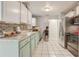 Functional kitchen with white and light blue cabinetry, stainless steel appliances, and tile backsplash at 840 Del Prado Dr, Kissimmee, FL 34758