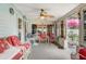 Bright sunroom filled with natural light, tile flooring, and white wicker furniture at 840 Del Prado Dr, Kissimmee, FL 34758