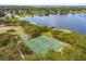 Aerial view highlighting a tennis court, basketball court, dock, and lakefront scenery at 8988 Angelica Dr, Orlando, FL 32836