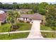 Aerial view of the charming home featuring mature landscaping, a long driveway, and serene neighborhood at 8988 Angelica Dr, Orlando, FL 32836