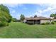 Expansive green backyard featuring the rear of the house and lush landscaping at 8988 Angelica Dr, Orlando, FL 32836