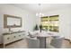 Bright dining room featuring modern chandelier, round table and accent furniture with a serene backyard view at 8988 Angelica Dr, Orlando, FL 32836
