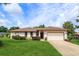 Charming single-story home with a well-maintained lawn, brick trim, and an attached two car garage at 8988 Angelica Dr, Orlando, FL 32836