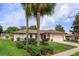 Charming one story home with palm trees and lush green lawn and landscaping at 8988 Angelica Dr, Orlando, FL 32836