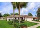 Beautiful one-story home with palm trees, red mulch, and manicured landscaping, showcasing curb appeal at 8988 Angelica Dr, Orlando, FL 32836