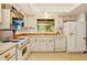 Bright kitchen with white appliances, cabinets, and a window with a view of the backyard at 8988 Angelica Dr, Orlando, FL 32836