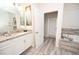 Bathroom featuring a double sink vanity with granite countertops, with a soaking tub and glass shower at 9014 Stinger Dr, Davenport, FL 33896