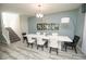 Modern dining room featuring a white dining table, stylish chairs, and open staircase at 9014 Stinger Dr, Davenport, FL 33896