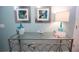 Console table with glass top and silver accents, adorned with decorative art and bright lamp at 9014 Stinger Dr, Davenport, FL 33896