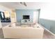 Stylish living room featuring a white leather sofa, TV, and open doorway at 9014 Stinger Dr, Davenport, FL 33896