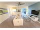 Well-lit living room with sofa, TV, and open layout to other rooms at 9014 Stinger Dr, Davenport, FL 33896