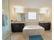 Luxurious bathroom with double vanity sinks and a soaking tub at 9257 Outlook Rock Trl, Windermere, FL 34786