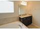Bathroom featuring soaking tub, vanity with countertop, and granite sink at 9257 Outlook Rock Trl, Windermere, FL 34786