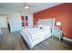 Cozy bedroom showcasing wood floors, a ceiling fan, and a decorative accent wall at 9257 Outlook Rock Trl, Windermere, FL 34786