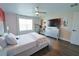 Bedroom featuring wood floors, a modern ceiling fan, and a large television at 9257 Outlook Rock Trl, Windermere, FL 34786