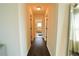 Bright hallway with wood floors leading to bathroom with tub at 9257 Outlook Rock Trl, Windermere, FL 34786