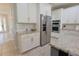 Well-lit kitchen boasting granite countertops, stainless steel appliances, and white cabinetry at 9257 Outlook Rock Trl, Windermere, FL 34786