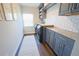 Well-lit laundry room with granite countertops, grey cabinets, modern backsplash and modern appliances at 9257 Outlook Rock Trl, Windermere, FL 34786