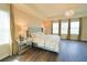 A beautifully staged primary bedroom showcases a tray ceiling, wood floors, a chandelier, and large windows at 9257 Outlook Rock Trl, Windermere, FL 34786