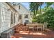 Outdoor dining area on brick patio, adjacent to the house with white shingle siding and trim at 1008 Delaney Park Dr, Orlando, FL 32806