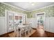 Elegant dining room with floral wallpaper, hardwood floors, and ample natural light at 1008 Delaney Park Dr, Orlando, FL 32806