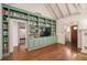 Spacious living room with a large bookcase, a mounted television, and hardwood flooring at 1008 Delaney Park Dr, Orlando, FL 32806