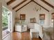 Vaulted ceiling bedroom with exposed beams, hardwood floors, and French doors leading to an outdoor pool at 1008 Delaney Park Dr, Orlando, FL 32806