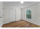 Bright bedroom featuring wood-look flooring, closet, and a window with a view of trees at 103 Gleason Cv, Sanford, FL 32773