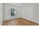 Bright bedroom featuring wood-look flooring and a window view of lush greenery at 103 Gleason Cv, Sanford, FL 32773