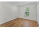 Cozy bedroom with wood-look flooring and a window view, filled with natural light at 103 Gleason Cv, Sanford, FL 32773