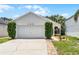 Home's exterior features a white garage door, landscaping and walkway at 103 Gleason Cv, Sanford, FL 32773