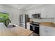 Bright kitchen features stainless steel appliances, white cabinets, butcher block countertops, and a view of greenery at 103 Gleason Cv, Sanford, FL 32773